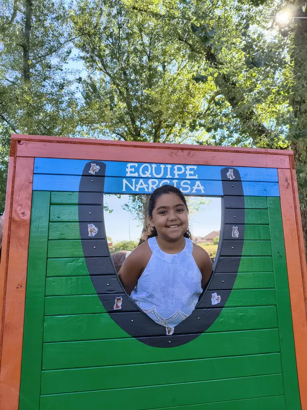 Una bambina posa nella cornice decorata di Equipe Narcisa