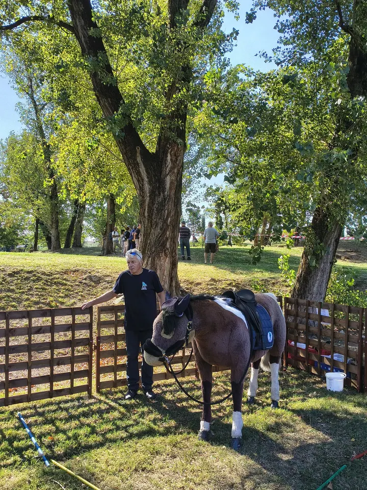 Un operatore di Equipe Narcisa accanto a un pony sellato