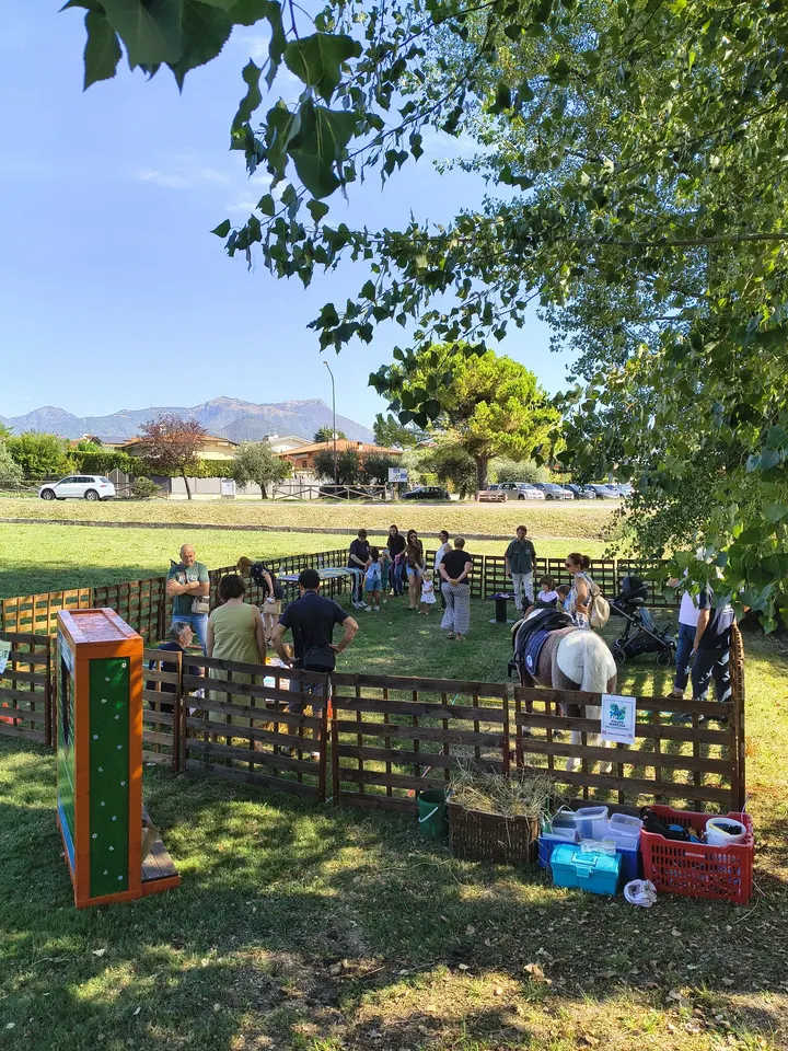 Panoramica del festival con visitatori, pony e montagne sullo sfondo